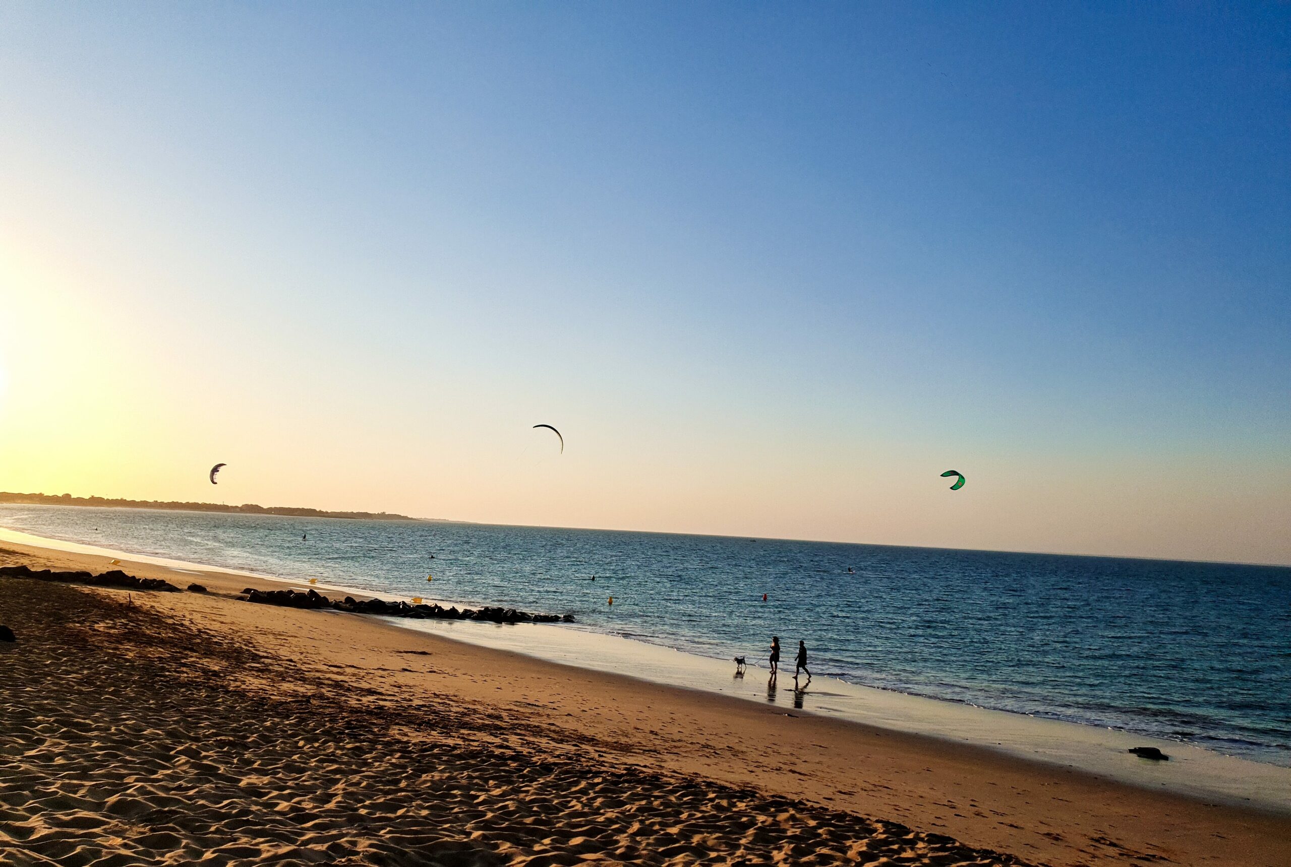 Kitesurfers on the Atlantic coast at sunset